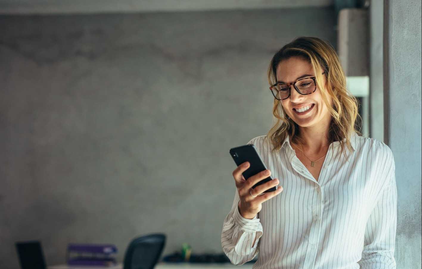 woman with glasses checking her phone