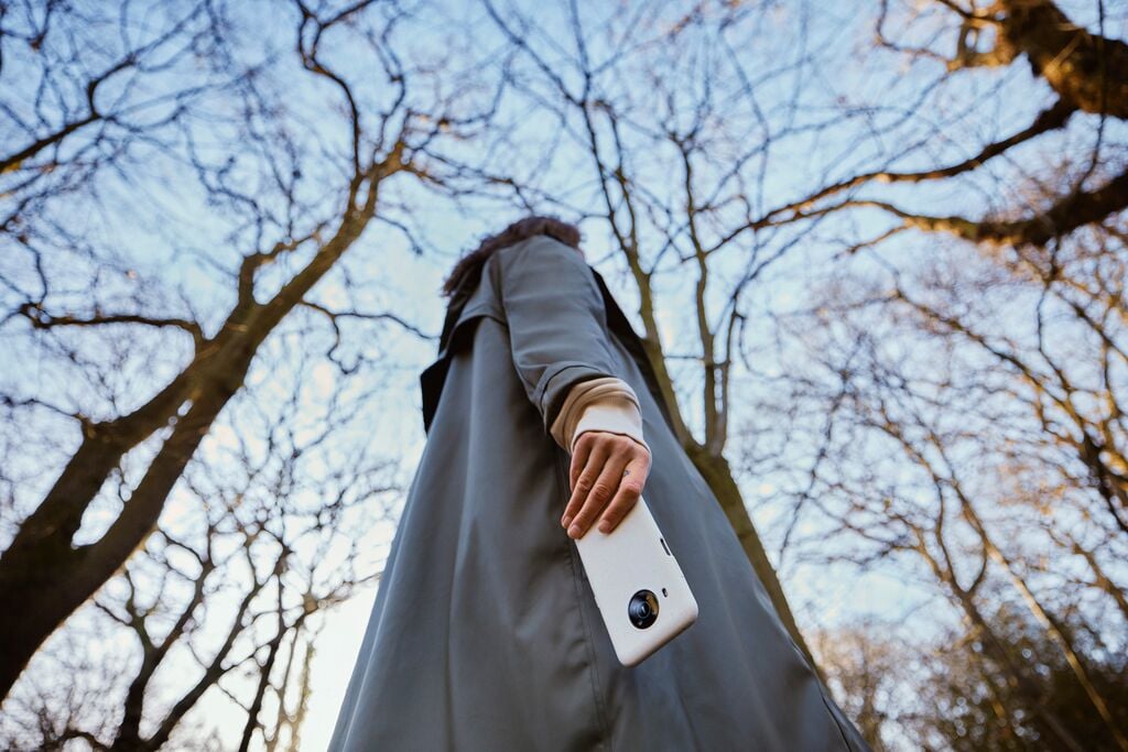 girl in a forest with phone in her hand